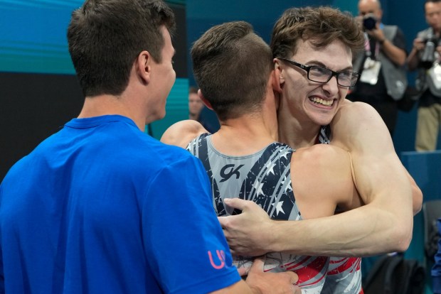 Stephen Nedoroscik, of United States, gets a hug from Paul Juda after last rotation during the men's artistic gymnastics team finals round at Bercy Arena at the 2024 Summer Olympics, Monday, July 29, 2024, in Paris, France. (AP Photo/Abbie Parr)