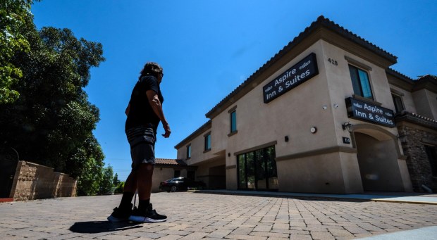 Roy, a 61-year-old who used to make medical devices, and who needs a cane or a walker to get around, stands in the driveway of the motel where he is staying in Orange, on Thursday, June 29, 2023. In Southern California, where the numbers of people 55 and up who are unhoused has more than doubled in the past seven years. The issue often isn't about addiction or mental health. It's about money. (Photo by Mark Rightmire, Orange County Register/SCNG)