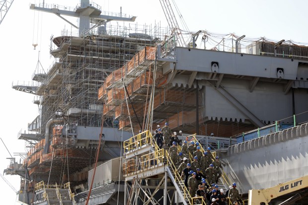 Newport News Shipbuilding workers and Navy sailors exit the USS George Washington as it rests pier side Friday morning October 11, 2019. The aircraft carrier is about halfway through Refueling and Complex Overhaul at Newport News Shipbuilding.