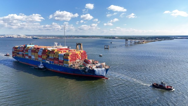 The container ship Dali is escorted through the Francis Scott Key Bridge collapse site on its way to Norfolk on Monday. (Jerry Jackson/Staff)