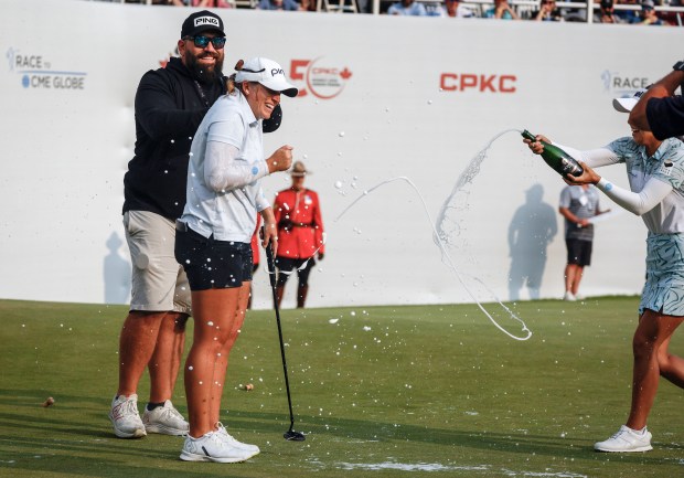 Lauren Coughlin, second from left, is sprayed with champagne after winning her first LPGA Tour title Sunday in Calgary, Alberta. JEFF MCINTOSH/THE CANADIAN PRESS VIA AP