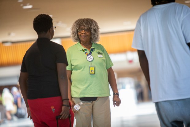 Vera Cornish greets travelers at Norfolk International Airport in Norfolk, Virginia, on July 19, 2024. Cornish has been a volunteer for seven years. (Billy Schuerman / The Virginian-Pilot)