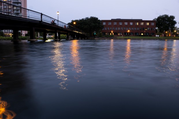 Streetlights reflect off the water in the Hague in Norfolk, Virginia, on Aug. 1, 2023. (Billy Schuerman / The Virginian-Pilot)