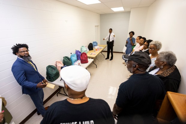 Visitors are guided by Major Erica McKeithan on a tour of the S.T.A.R. Center in Hampton, Virginia, on July 25, 2024. Backpacks displayed are donated and contain hygiene and education materials. (Billy Schuerman / The Virginian-Pilot)