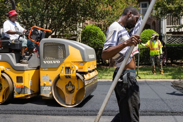 Excel Paving Corporation worker Eric Franklin wipes his sweat onto a towel in between laying asphalt on Delaware Ave. and Colonial Ave. at noon with the temperature at 90 degrees Fareneheit and the heat index at 100 degrees Fahrenheit in Norfolk, Va. on Thursday, July 13, 2023. Temperatures are expected to increase as Norfolk experiences a heatwave. (Tess Crowley / The Virginian-Pilot)