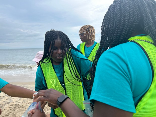 Portsmouth student Janae Washington, 13, collects samples at the Virginia Beach Oceanfront as part of a Camp Answer activity on Wednesday, July 24, 2024. (Nour Habib/The Virginian-Pilot)