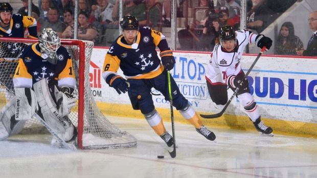 Norfolk defenseman Dakota Krebs handles the puck near the Admirals' goal as Adirondack forward Yushiroh Hirano pursues him during Game 6 of the ECHL North Division finals on Tuesday night in Glens Falls, New York. (Courtesy of Andy Camp)