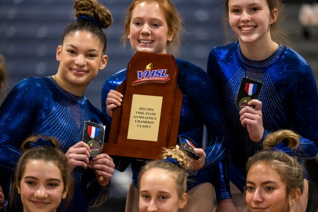 Ocean Lakes teammates take a photo with their trophy after taking first place in the VHSL Class 5 gymnastics championship at Ocean Lakes High School in Virginia Beach on Friday, Feb, 16, 2024. (Kendall Warner / The Virginian-Pilot)