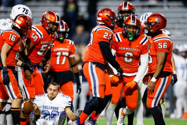 Maury Jaden Ratliff (6) is celebrated by teammates after a big hit knocked the helmet off of Stone Bridge running back Kaden Irizarry (20). Maury defeated Stone Bridge 45-34 in the class 5 state championship at Scott Stadium in Charlottesville, Virginia on Dec. 9, 2023. (Billy Schuerman / The Virginian-Pilot)