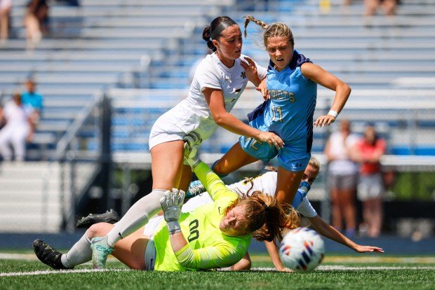 First Colonial attacker Sydney Miller (11) fights through the defense of Kellam goalkeeper Anna Wise (00), Brooke Owens (7), left, and Taylor Garofalo (23), behind. Kellam defeated First Colonial 4-2 in penalty kicks in the class 5 soccer state championships at J.R. Tucker High School in Henrico, Virginia, on June 8, 2024. (Billy Schuerman / The Virginian-Pilot)