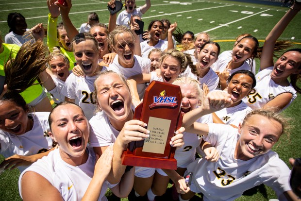 Kellam players hoist the championship trophy after on the field after defeating First Colonial 4-2 in penalty kicks in the class 5 soccer state championships at J.R. Tucker High School in Henrico, Virginia, on June 8, 2024. (Billy Schuerman / The Virginian-Pilot)