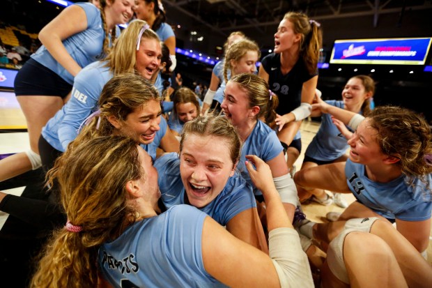 First Colonial players swarm their teammates on the court after defeating Riverside 3-1 in the Class 5 state championship at the Siegel Center on Nov. 17, 2023 in Richmond, Virginia. (Billy Schuerman / The Virginian-Pilot)