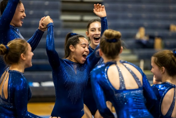 Ocean Lakes teammates celebrate winning first place in the VHSL Class 5 gymnastics championship at Ocean Lakes High School in Virginia Beach on Feb. 16, 2024. (Kendall Warner / The Virginian-Pilot)