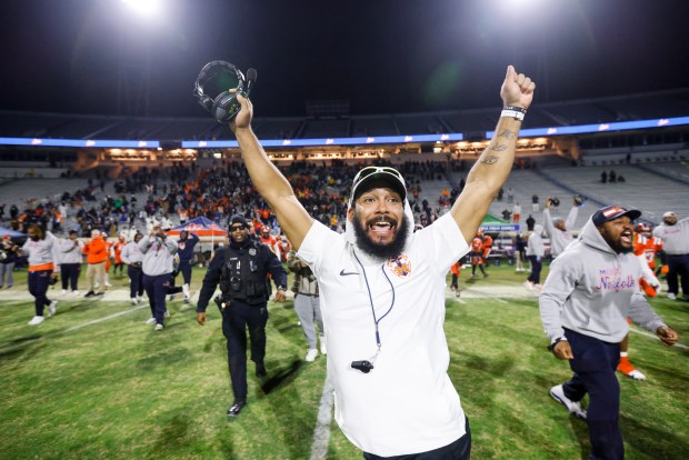 Maury head coach Dyrri McCain throws his arms into the air to celebrate defeating Stone Bridge 45-34 in the class 5 state championship at Scott Stadium in Charlottesville, Virginia on Dec. 9, 2023. (Billy Schuerman / The Virginian-Pilot)