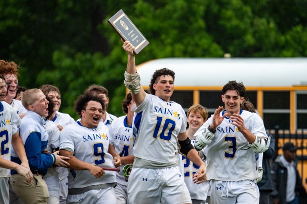 Nansemond-Suffolk Academy players hold up the state championship award to family and friends after defeating North Cross in the VISAA Division II boys lacrosse state championship game at Nansemond-Suffolk Academy on Saturday, May 18, 2024, in Suffolk, Va. (Mike Caudill for The Virginian-Pilot)